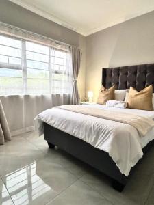 a bedroom with a large bed with a large window at Caysa Villa in Gaborone