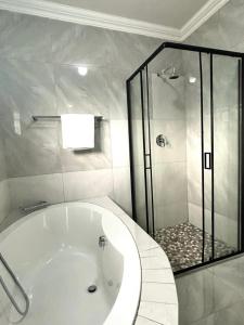 a bathroom with a large tub and a shower at Caysa Villa in Gaborone