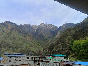 a view of a mountain range with houses and mountains at Swastik Hotel & Restaurant in Kharsālī