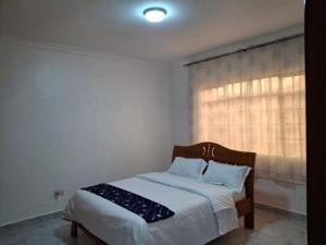 a bedroom with a bed and a window at BlessRoyal Home in Kitengela 