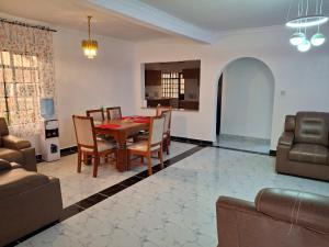 a dining room and living room with a table and chairs at BlessRoyal Home in Kitengela 