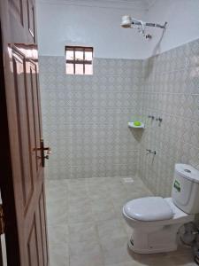 a bathroom with a toilet and a shower at BlessRoyal Home in Kitengela 