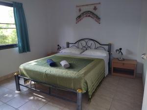 a bedroom with a bed with a green blanket at Sabai Residence in Ao Nang Beach