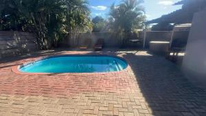 a small swimming pool on a brick patio at Happy Time guest house in Phalaborwa