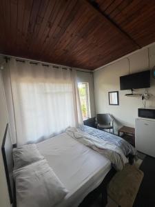 a bedroom with a bed with a window and a television at Happy Time guest house in Phalaborwa +22 photos
