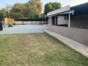 a yard next to a building with a driveway at Happy Time guest house in Phalaborwa