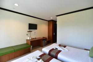 a hotel room with two beds and a tv at The Green Hotel in Ko Lipe