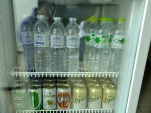 a refrigerator filled with lots of bottles of water at Chada Veranda Hotel in Ban Si Than