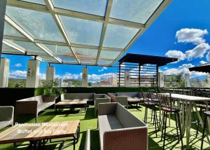 a rooftop patio with tables and chairs on a building at Citylight Hotel in Baguio