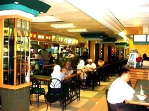 a group of people sitting at tables in a restaurant at The CentrePoint Hotel in Kampong Kiulap