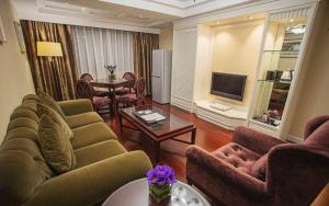 a living room with two couches and a television at Teda Dalian in Dalian