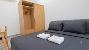 a bed with two towels on top of it at Axis Residences By The Team in Phnom Penh +7 photos