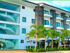 a building with palm trees in front of it at Ciriaco Hotel in Rauis