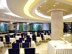 a banquet hall with white tables and blue chairs at Changchun Global Hotel in Changchun