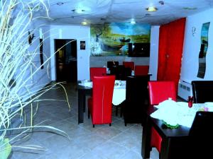 マフムディアにあるPensiunea Casa Cornelia Mahmudiaの赤い椅子とテーブルが備わるレストラン
