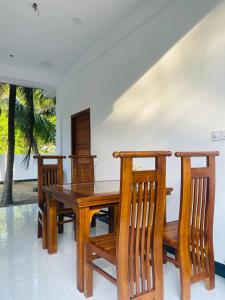 a dining room with a wooden table and chairs at Nachchi Beach Sweet Stay in Nilaveli +66 photos