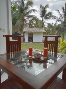a table with a plate of food and two glasses on it at Nachchi Beach Sweet Stay in Nilaveli