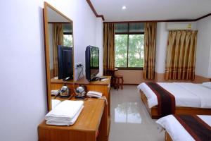 a hotel room with two beds and a mirror at PC Palace Hotel in Sakon Nakhon