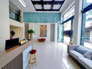a living room with a couch and a bar at Mount Emei Fulin Hotel in Baoguosi