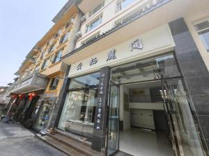 a store front of a building with glass windows at Mount Emei Fulin Hotel in Baoguosi
