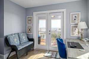a living room with a table and a chair and a desk at Ohana in Holden Beach