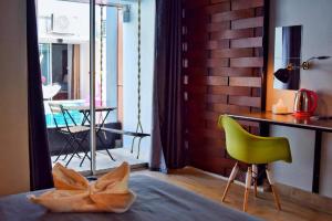 a kitchen with a green chair and a table with a dining room at Z2 Boutique Hotel in Ban Samet