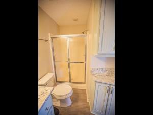 a small bathroom with a toilet and a shower at Ohana Tides Home in Holden Beach
