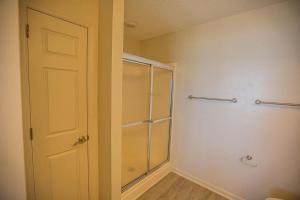 a bathroom with a walk in shower next to a door at Ohana Tides Home in Holden Beach +66 photos
