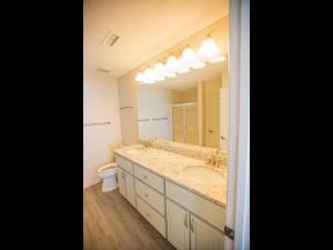 a bathroom with a sink and a large mirror at Ohana Tides Home in Holden Beach