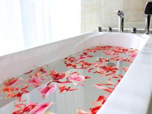 a bath tub filled with pink flowers painted on it at Pacific Regency Hotel Shenyang in Shenyang +102 photos