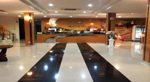 a lobby with a counter and a vase of flowers at Mukdaview Hotel in Mukdahan
