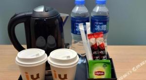 a table with two cups of coffee and bottles of water at IU Hotel Baoding Goverment Shidai in Baoding