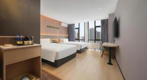 a hotel room with two beds and a television at IU Hotel Baoding Goverment Shidai in Baoding +287 photos