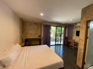 a bedroom with a white bed and a table and chairs at palmhouse in Mae Hong Son