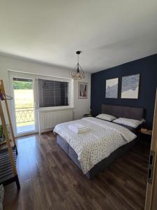 a bedroom with a bed and a blue wall at Under The Castle in Dob