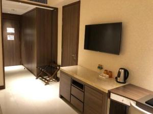 a kitchen with a flat screen tv on the wall at Jai Alai Hotel in Macau