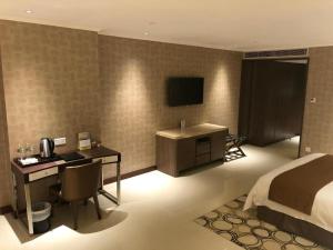 a hotel room with a bed and a desk with a computer at Jai Alai Hotel in Macau