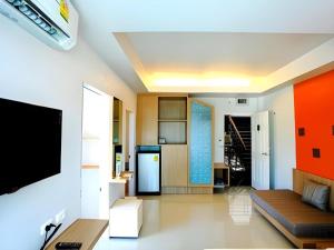 a living room with a couch and a tv at Tonkok Hotel in Ban Fang Min