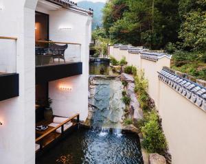 a house with a waterfall in the middle of a garden at Tiantai Hotel in Wachangtan