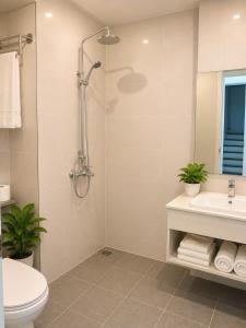 a bathroom with a shower and a toilet and a sink at Blue Hotel Sunset Town Phu Quoc in Phú Quốc +23 photos