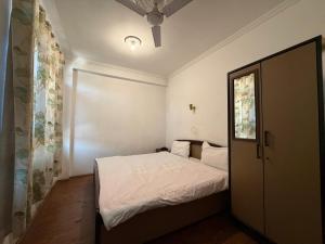 a small bedroom with a white bed and a window at City Star in Srinagar