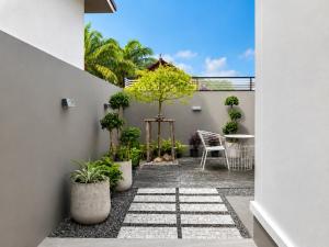 a courtyard with potted plants and a table at The Phuview Pool Villa Aonang in Ban Chong Phli