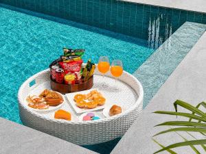 a table with food and drinks next to a swimming pool at The Phuview Pool Villa Aonang in Ban Chong Phli
