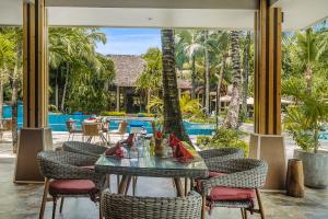 a dining room with a table and chairs and a pool at Niva Labriz Seychelles in Silhouette Island +28 photos