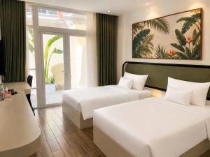 a hotel room with two beds and a window at Blue Hotel Sunset Town Phu Quoc in Phú Quốc