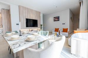 a living room with a table with chairs and a television at Amber Hospitality - Arrawdha in Riyadh
