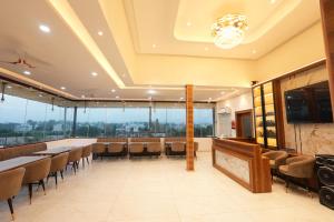 a restaurant with tables and chairs and windows at hotel baromas retreat in Jawālāpur