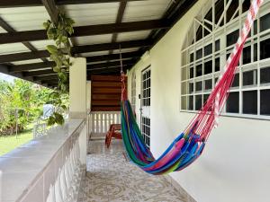 a hammock on the porch of a house at EV's Place in San Ignacio
