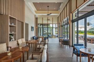 a restaurant with tables and chairs and windows at Meliá Ho Tram Beach Resort in Ho Tram