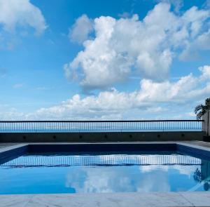 a swimming pool with the sky in the background at Vitória Marina Flat in Salvador